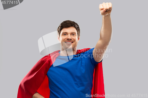 Image of man in red superhero cape over grey background