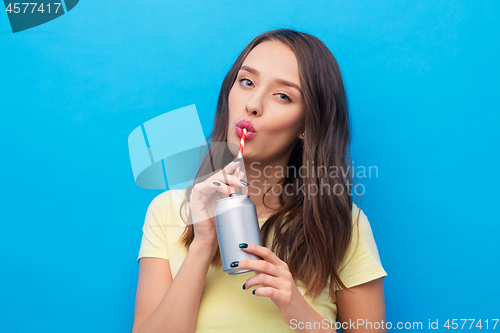 Image of young woman or teenage girl drinking soda from can