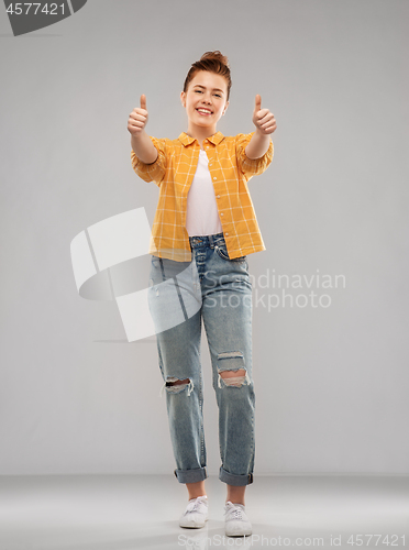 Image of happy red haired teenage girl showing thumbs up