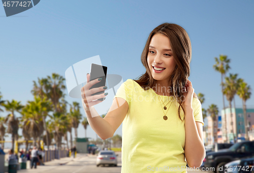 Image of teen girl takes selfie by cell over venice beach