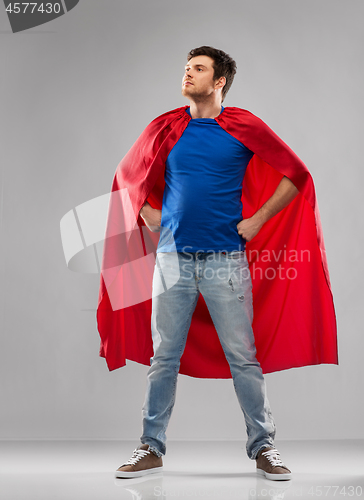 Image of man in red superhero cape over grey background