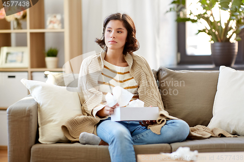 Image of sick woman taking paper tissue from box at home