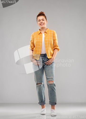 Image of red haired teenage girl in shirt and torn jeans