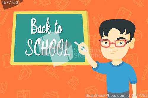 Image of Boy writing text back to school on the blackboard.