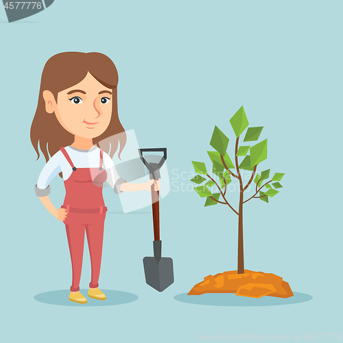 Image of Young caucasian woman planting a tree.