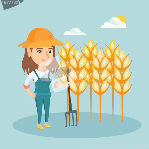 Image of Young farmer standing in a field with pitchfork.