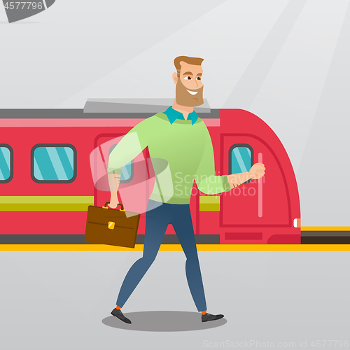 Image of Young man walking on a railway station platform.