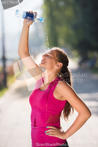 Image of woman pouring water from bottle on her head