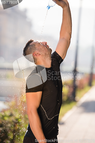 Image of man pouring water from bottle on his head