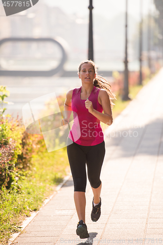 Image of woman jogging at sunny morning