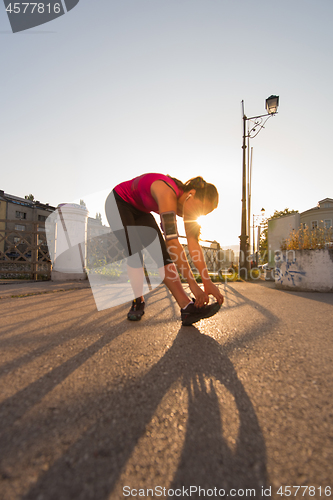 Image of athlete woman warming up and stretching