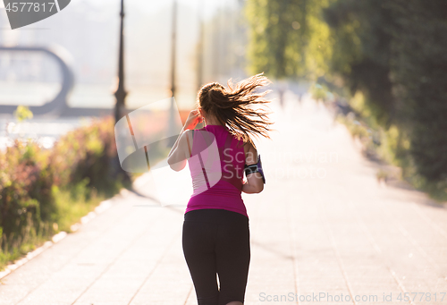 Image of woman jogging at sunny morning