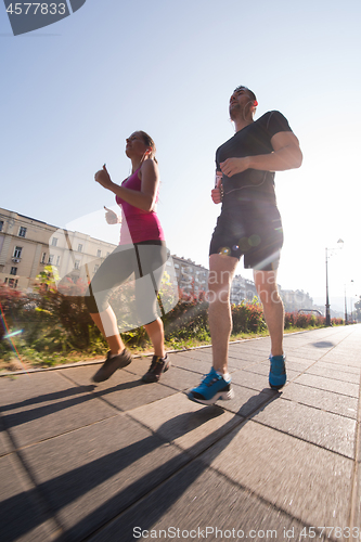 Image of young couple jogging  in the city