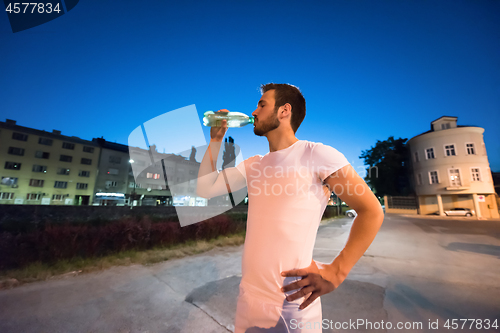 Image of man drinking water after running session