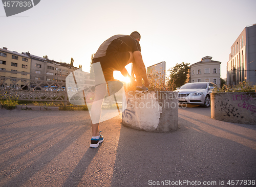 Image of man tying running shoes laces