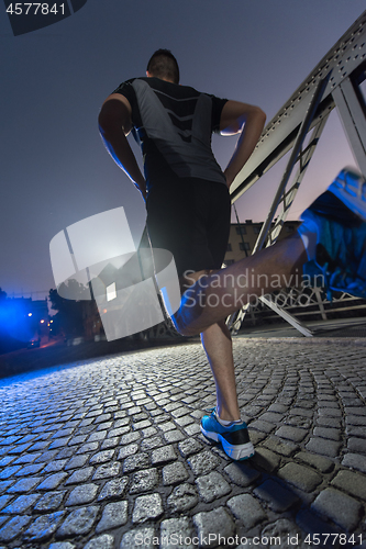 Image of man jogging across the bridge in the city