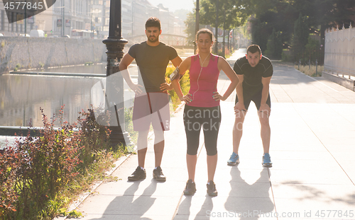 Image of group of young people jogging in the city