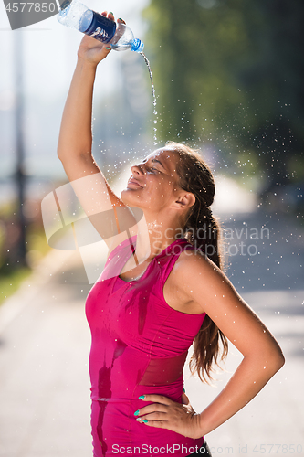 Image of woman pouring water from bottle on her head