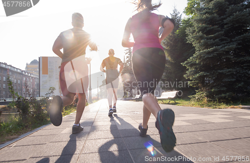 Image of group of young people jogging in the city