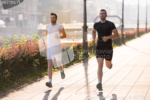 Image of group of young people jogging in the city