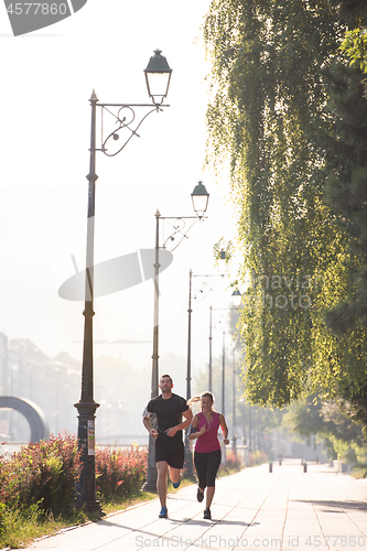 Image of young couple jogging  in the city