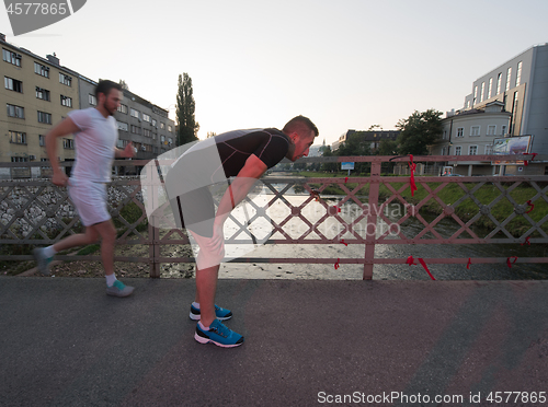 Image of group of young people jogging across the bridge