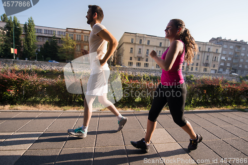 Image of young couple jogging  in the city