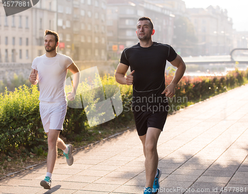 Image of group of young people jogging in the city