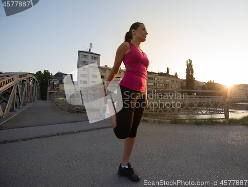 Image of athlete woman warming up and stretching