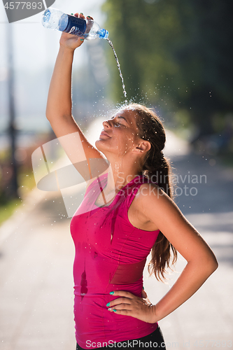 Image of woman pouring water from bottle on her head