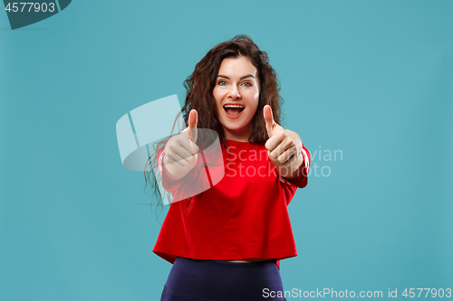 Image of The happy business woman standing and smiling against blue background.