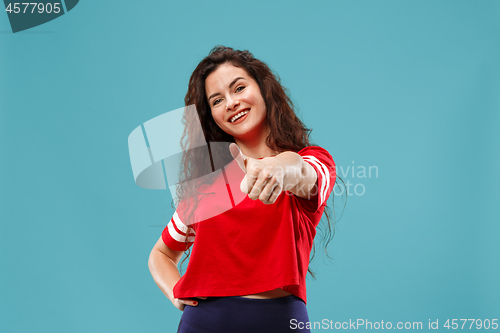 Image of The happy business woman standing and smiling against blue background.