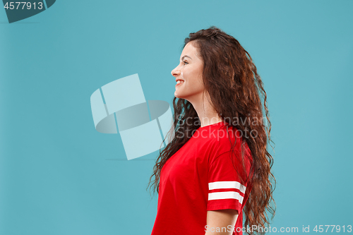 Image of The happy business woman standing and smiling against blue background.