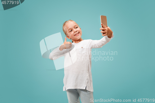 Image of The happy teen girl making selfie photo by mobile phone