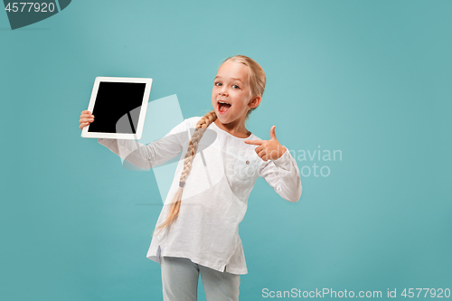 Image of Little funny girl with tablet on blue background