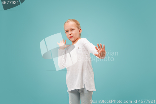 Image of Doubtful pensive teen girl rejecting something against blue background