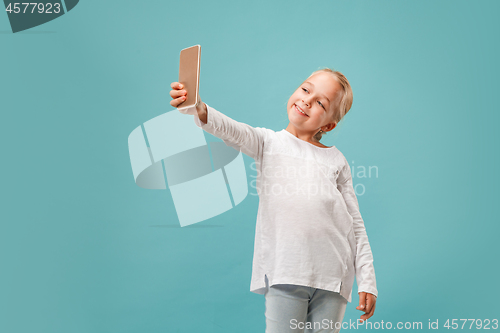 Image of The happy teen girl making selfie photo by mobile phone