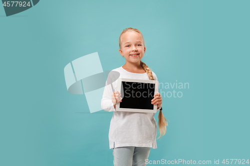 Image of Little funny girl with tablet on blue background