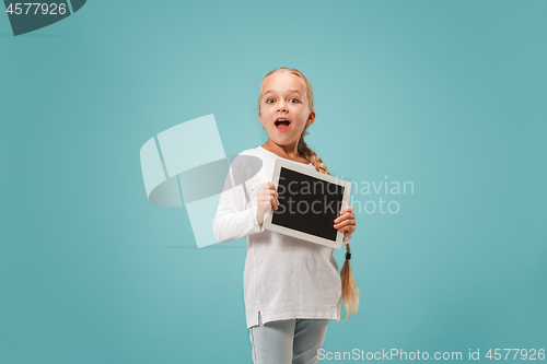 Image of Little funny girl with tablet on blue background