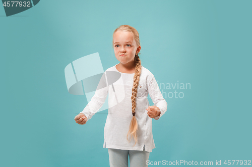 Image of Portrait of angry teen girl on a blue studio background