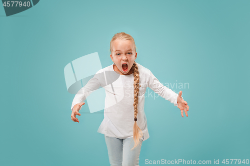 Image of Portrait of angry teen girl on a blue studio background