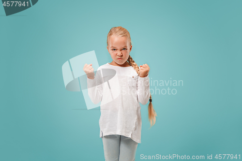 Image of Portrait of angry teen girl on a blue studio background