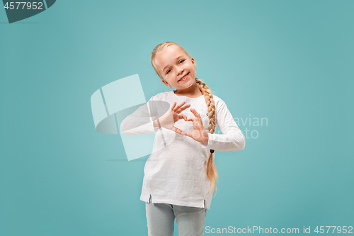 Image of Beautiful smiling teen girl makes the shape of a heart with her hands on the blue background.