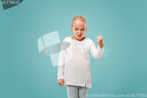 Image of Portrait of angry teen girl on a blue studio background