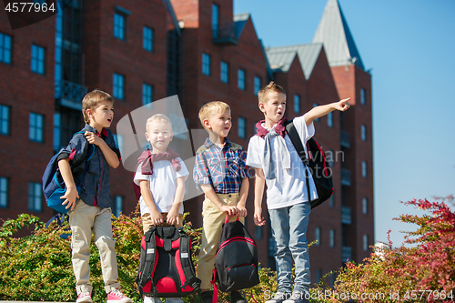 Image of A group of children of school and preschool age are standing against sity