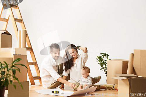 Image of Couple moving to a new home - Happy married people buy a new apartment to start new life together