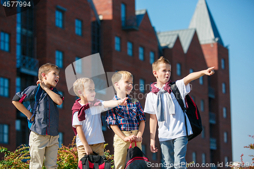 Image of A group of children of school and preschool age are standing against sity