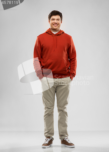 Image of young man in red hoodie over grey background