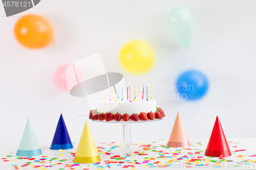 Image of birthday cake with candles and strawberries