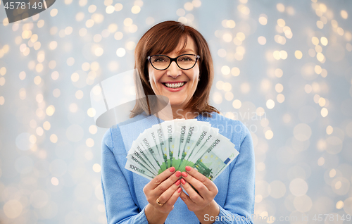 Image of senior woman with hundreds of euro money banknotes